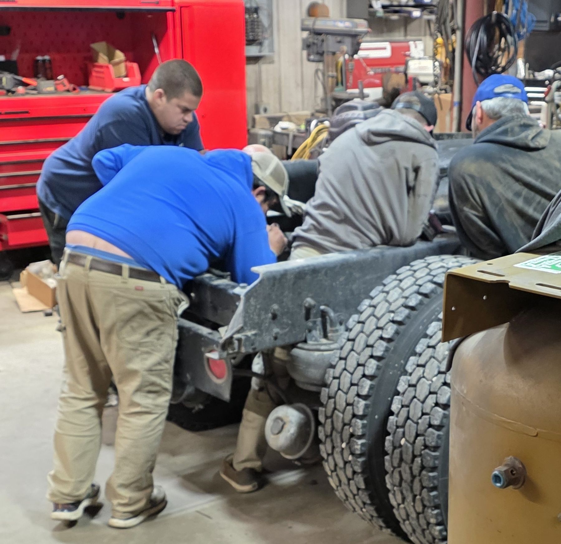 Lauramie technicians working under the hood of a vehicle in the shop